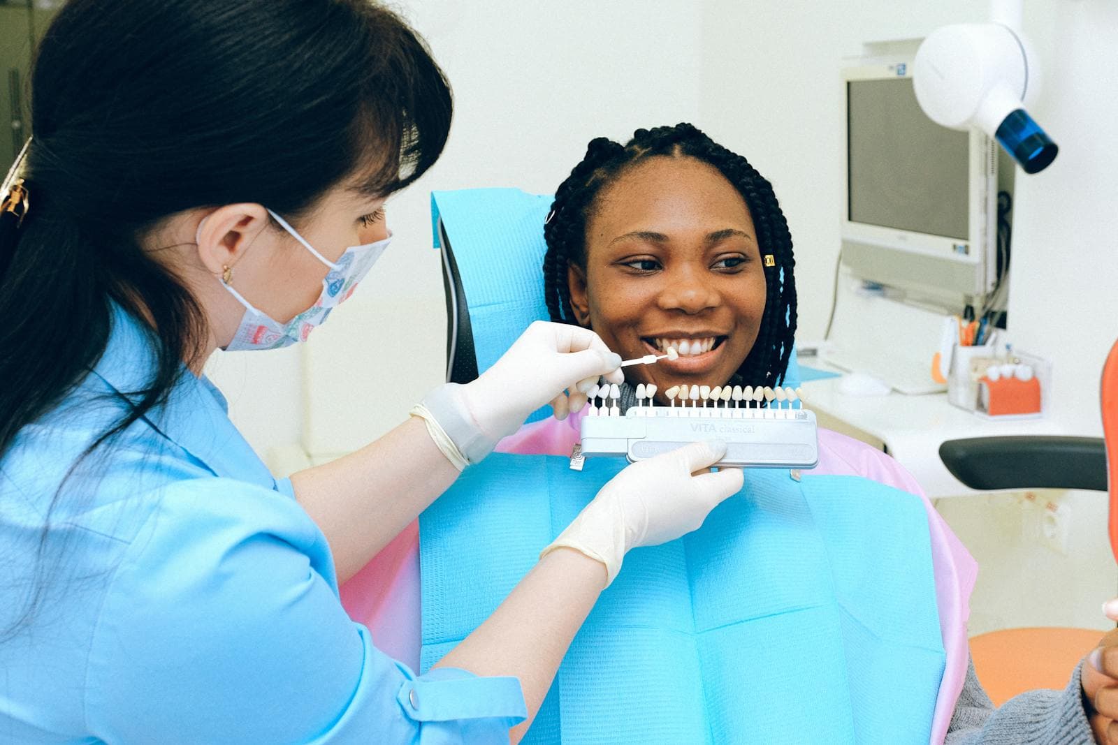 Dentist consulting a patient with tooth whitening shade samples
